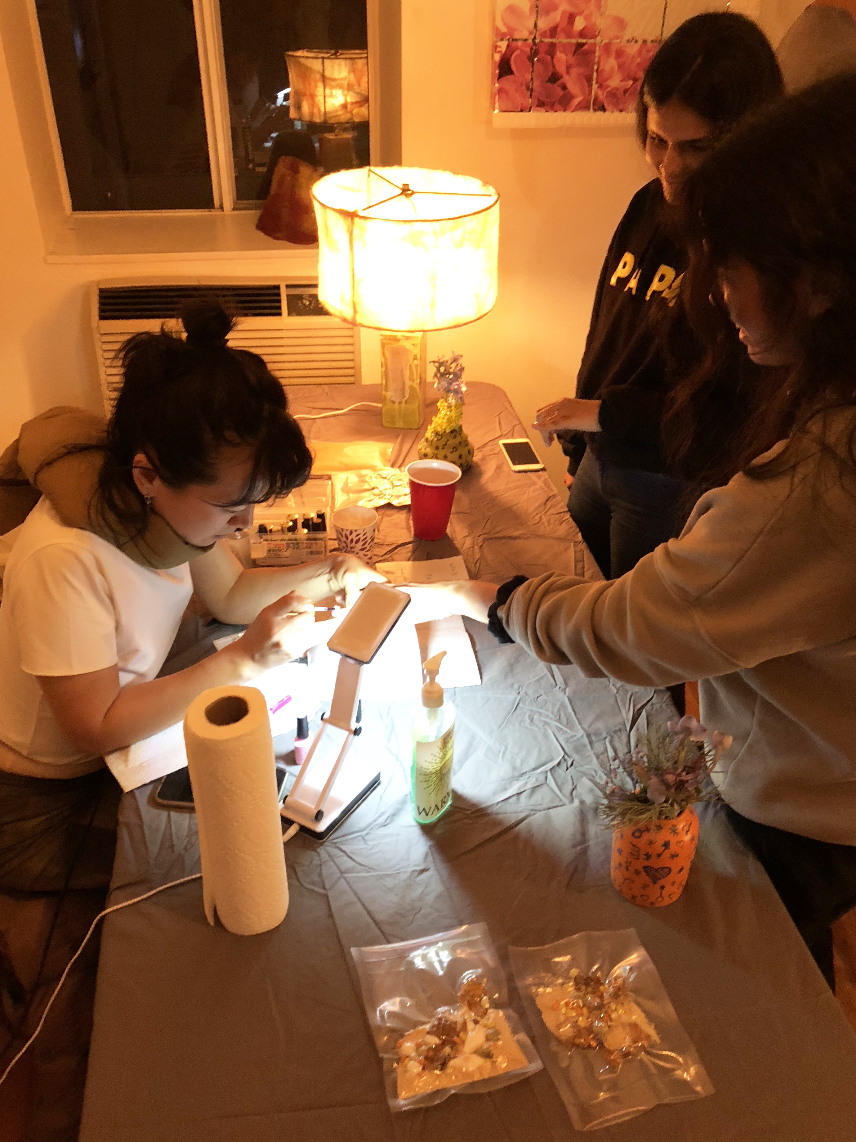 A woman doing another woman's nails on a gray table